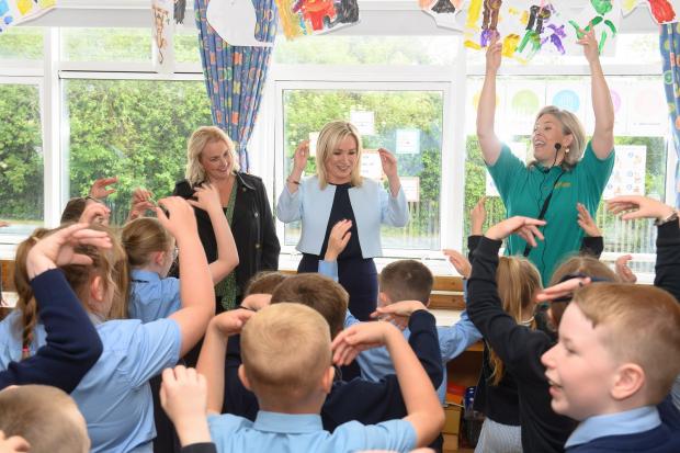 The First Minister Michelle O’Neill (centre) and Junior Minister Pam Cameron (left) taking part in a music workshop led by Associate facilitator Anne Harper (right)  with P3 pupils from Good Shepherd Primary School. 